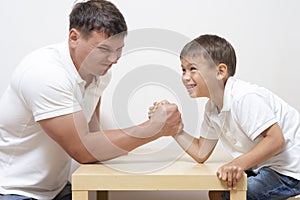 Mens Things. Father with His Little Son Having Arm-Wrestling Session Indoors. Showing Physical and Emotional Tension