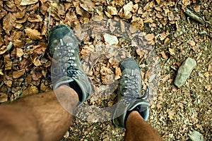 Mens trekking shoes while hiking in forest