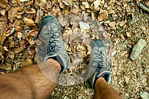 Mens trekking shoes while hiking in forest