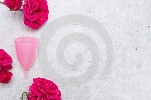 Menstrual cup with flowers on gray background. Menstruation concept