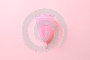 Menstrual cup on pink background, close up