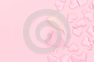 Menstrual cups and confetti in a heart shape on a pink background.