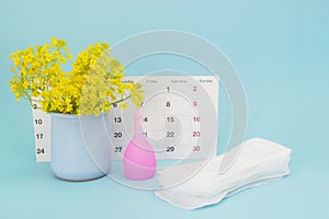Menstrual pads and menstrual cup for blood period. Menstruation period pain protection. Feminine hygiene products and yellow