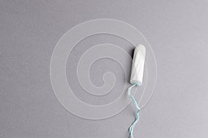 Menstrual tampon on a grey background. Menstruation cycle. Hygiene and protection