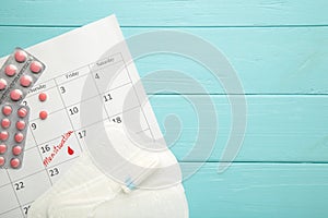 Menstruation calendar with cotton tampons and pads on blue background. Woman critical days, woman hygiene protection. Menstrual