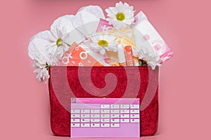 Menstruation calendar with cotton tampons , sanitary pads, white flower . Woman critical days, woman hygiene protection