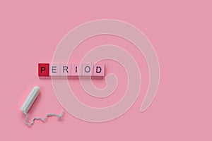 Menstruation concept: word period spelled with pink letters on pink background with a tampon