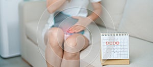 Menstruation period cycle of monthly and Stomachache concepts. woman having abdomen pain with hot water bottle and calendar,