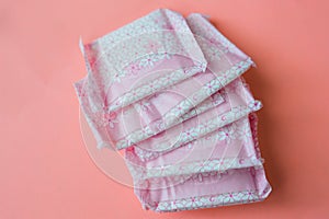 Menstruation, Wrapped pink period pads against pink background photo
