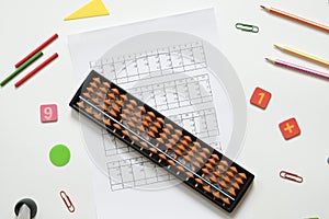Mental arithmetic and math concept: colorful pens and pencils, numbers, abacus scores on white background, copy space