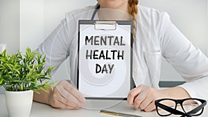 Mental Health Day text written on a paper tablet in a doctor`s hand