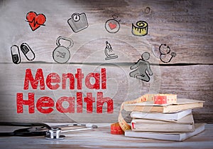 Mental Health. Stack of books and a stethoscope on a wooden background