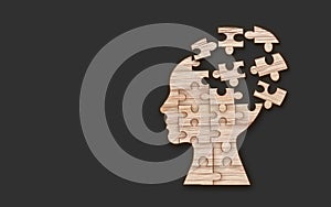 Mental health symbol. Human head silhouette with a puzzle cut out from wooden background