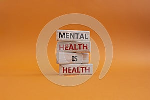 Mental Health symbol. Wooden blocks with words Mental Health is Health. Beautiful orange background. Medical and Health concept.