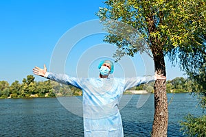 Mental health  during the Virus Covid 19 A man enjoying intense contact with nature. Open arms on the river bank.