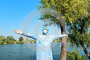 Mental health  during the Virus Covid 19 A man enjoying intense contact with nature. Open arms on the river bank.