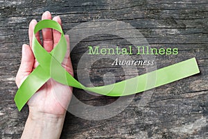 Mental illness awareness with Lime Green ribbon color  on helping hand
