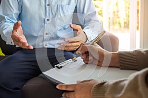 Mental illness. Female psychologists is writing male patient information to a clipboard