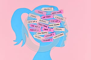 Mental load concept with woman`s head silhouette with multiple tasks on notes photo