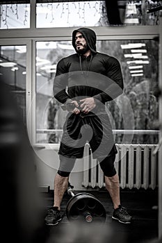 Mental and physical growth concept of hard workout training in gym by strong young athlete caucasian man wearing hoodie and