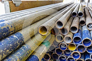 Mental scaffold pipe stack together on scaffold plank wood shelve with blue, green and yellow mark at the tip for build the tempo