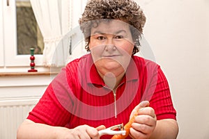 Mentally disabled woman is peeling carrots