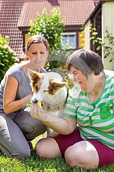 Mentally disabled woman with a second woman and a companion dog