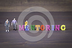 Mentoring. colored wooden letters on a dark background