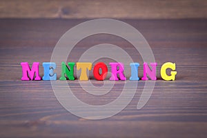 Mentoring. colored wooden letters on a dark background