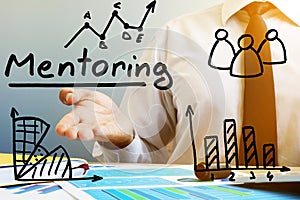 Mentoring concept. Mentor at the table in the office.