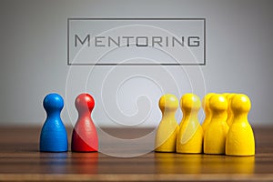 Mentoring concept with pawn figurines on table