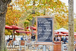 Menu board with words `hot wine` in three languages in Parisian outdoor cafe