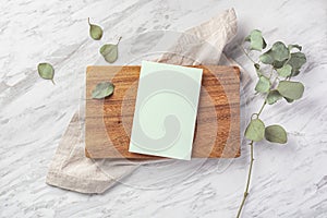 Menu card on wood board with linen napkin on marble table