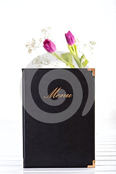 Menu and flowers on table