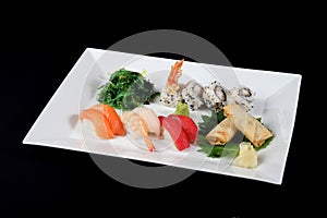 Menu of sushi and roll fish with vegetables on white plate