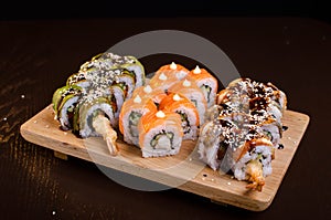 Menu of Ukrainian seafood restaurant. Japanese sushi rolls. Sushi set maki with shrimp,  tuna, eel and avocado. Dish on a wooden