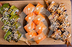 Menu of Ukrainian seafood restaurant. Japanese sushi rolls. Sushi set maki with shrimp,  tuna, eel and avocado. Dish on a wooden