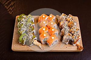 Menu of Ukrainian seafood restaurant. Japanese sushi rolls. Sushi set maki with shrimp,  tuna, eel and avocado. Dish on a wooden