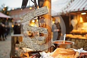 Menu written in different languages on wooden plates on the most authentic Christmas market in Riga offering dozens of crafts and