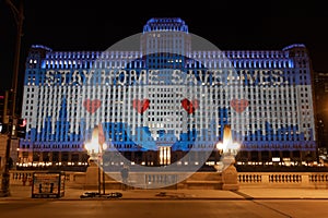 Merchandise Mart decorated with lights saying Stay Home, Save Lives captured in Chicago, USA