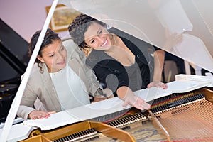 Merchandiser showing grand piano to customer