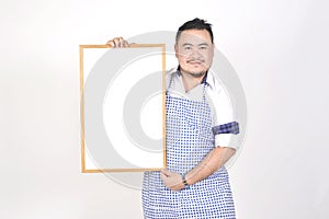 Merchant Asian man in white and blue apron to holding blank white broad for put some text or wording for present advertising