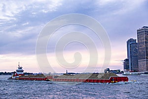 Merchant ship sailing loaded with piles of sand in New York City, USA