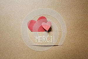 Merci - Thank you in French language with small hearts