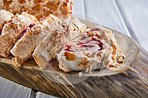 Merengue pie with pistachios and jam on a wooden board