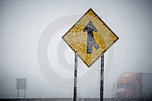 Merge sign barely seen through winter storm