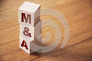 Mergers and acquisitions, M and A business concept. Letters on wooden cubes