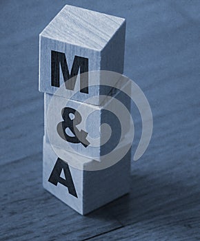 Mergers and acquisitions, M and A business concept. Letters on wooden cubes