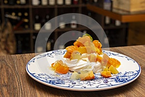 Meringue cake `Pavlova` with fresh yellow fruits and whipped cream.