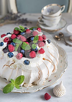 Meringue cake with raspberries and blueberry jam. Provence vintage style, ancient cruisers, cups, spoons